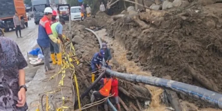 Petugas Kementerian PU membersihkan material banjir pada fasilitas publik di kawasan perkantoran Arosuka, Kabupaten Solok